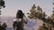 Back view happy tourist woman hiking, taking smartphone photo of amazing Grand Canyon national park mountain scenery.