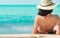 Back view of happy young Asian woman in pink swimsuit and straw hat relax and enjoy holiday at tropical paradise beach at sunset.