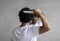 Back view of indian curly man combing hair standing near mirror in bathroom. Male haircare routine concept