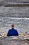 Back View of Japanese Male Monk in Blue Robe Praying on River Bank