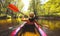 Back view Kayaking couple in river. POV of woman and man kayaking in beautiful landscape. Aquatic sports during fall autumn