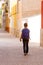 Back view of kid with backpack outdoors in european city.