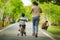Back view lifestyle portrait of mother and young happy son at city park having fun together the kid learning bike riding and the