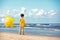 Back view of little boy with ballons on the beach