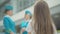 Back view of little brunette girl looking at blurred stewardesses talking in airport terminal. Close-up of Caucasian
