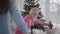 Back view of little Caucasian girl helping mother to decorate Christmas tree. Beautiful blond Caucasian woman and her