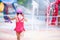 Back view of little child girl in the water park. Children wearing red swimming suit.