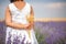 Back view of a little girl in lavender field holdig and holding bunch of wheat