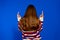 Back view of little girl pointing up at wall. Adorable girl standing pointing whit finger. Rear view. Isolated on blue