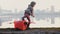 Back view of little pilot boy getting out of fun red cardboard plane at amazing peaceful city lake panorama slow motion.