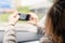 Back view of lonely girl with mobile phone near rainy window with drop of car