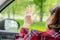 Back view of lonely girl touching by hand rainy window with drop of car.