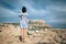 Back view of lonely woman standing on rocky desert