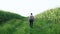 Back view of male farmer walks along the road along the fields of corn, in his hand carries a tablet. Senior man farmer