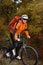 Back view of a man with a bicycle and red backpack against the blue sky. cyclist rides a bicycle.