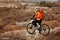 Back view of a man with a bicycle and red backpack against the blue sky. cyclist rides a bicycle.