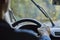 Back view of a man driving a car with moving windshield wipers during rain