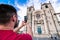 Back view of man, making shot of facade of cathedral in Porto. Tourist with beard taking a photo of Porto Cathedral or Se Catedral