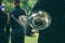 back view of a man in military uniform holding a French horn instrument