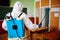 Back view of a man wearing disinfection equipment sanitizing the classroom before the academic year begins to protect from