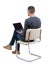 Back view of a man who sits on a chair with a laptop