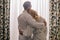 back view of mature couple in love wearing bathrobes and hugging in hotel