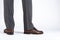 Back View of Mens Legs Wearing Brown penny Loafers. Against White Background