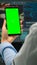 Back view of microbiologist looking at mobile phone with green mockup
