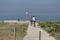 Back view of middle-aged couple, cycling on the eco pedestrian / bike path, near the sea