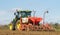 Back view of Modern John Deere tractor drilling seed in field