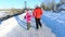 Back view mother and daughter running in winter park. Happy wintertime