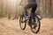 Back view of mountain biker riding on bike in autumn inspirational forest landscape, guy cycling MTB on enduro trail track, male