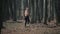 Back view of muscular caucasian man in running trousers walk in autumn forest. leaves fall in the background.