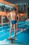 back view of muscular swimmer in swimming trunks standing