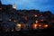 The back view on the old town of Matera in the night with the shinings lamp in the background