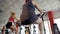 Back view of overweight and slim women training on stationary bike in sports gym