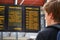 Back view of a passenger checking train timetable