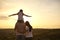 Back view of peaceful family watching sunset at mountains, copy space. Parents with child enjoying evening scenery