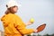 back view pickleball game woman player, hands over blue sky hitting pickleball yellow ball with paddle, outdoor sport