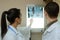 Back view: picture of two doctors exploring spinal x-ray: lumbar and cervical region - first 2 cervical vertebrae