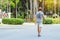 Back view portrait of a Asian elderly man in fitness wear walking and jogging for good health in public park. Senior jogger in