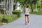 Back view portrait of a Asian elderly man in fitness wear walking and jogging for good health in public park. Senior jogger in