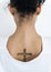 Back view portrait of a woman with a cross tattoo