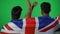 Back view positive Middle Eastern friends gesturing success supporting British football team on green screen. Happy