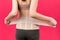 Back view of pregnant woman putting on supporting bandage to reduce backache at pink background with copy space. Cropped image of