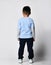 Back view of preschool little asian boy in blue t-shirt and sweatpants, sneakers