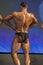 Back View of Professional Male Caucasian Bodybuilder Performing