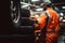 Back view of professional mechanic and new car tyre stack at auto repair shop. Technician man at auto repair service center.