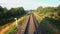 Back view of railroad and a beautiful green nature from a train passing on countryside land. Railroad travel or railway