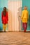 back view of retro styled women standing at door at colorful apartment doll